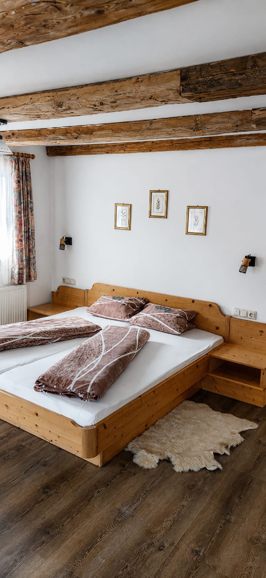 Schlafzimmer mit Holzbett in einer Ferienwohnung im Gasthof Sandwirt